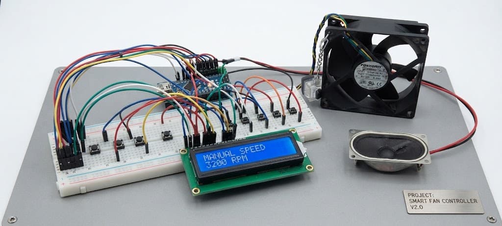 The BreezeBrain rig: an Arduino wired across a breadboard to a 16x2 LCD reading MANUAL SPEED 3200 RPM, an 80mm case fan, a speaker and a row of control buttons, all mounted on a grey panel.